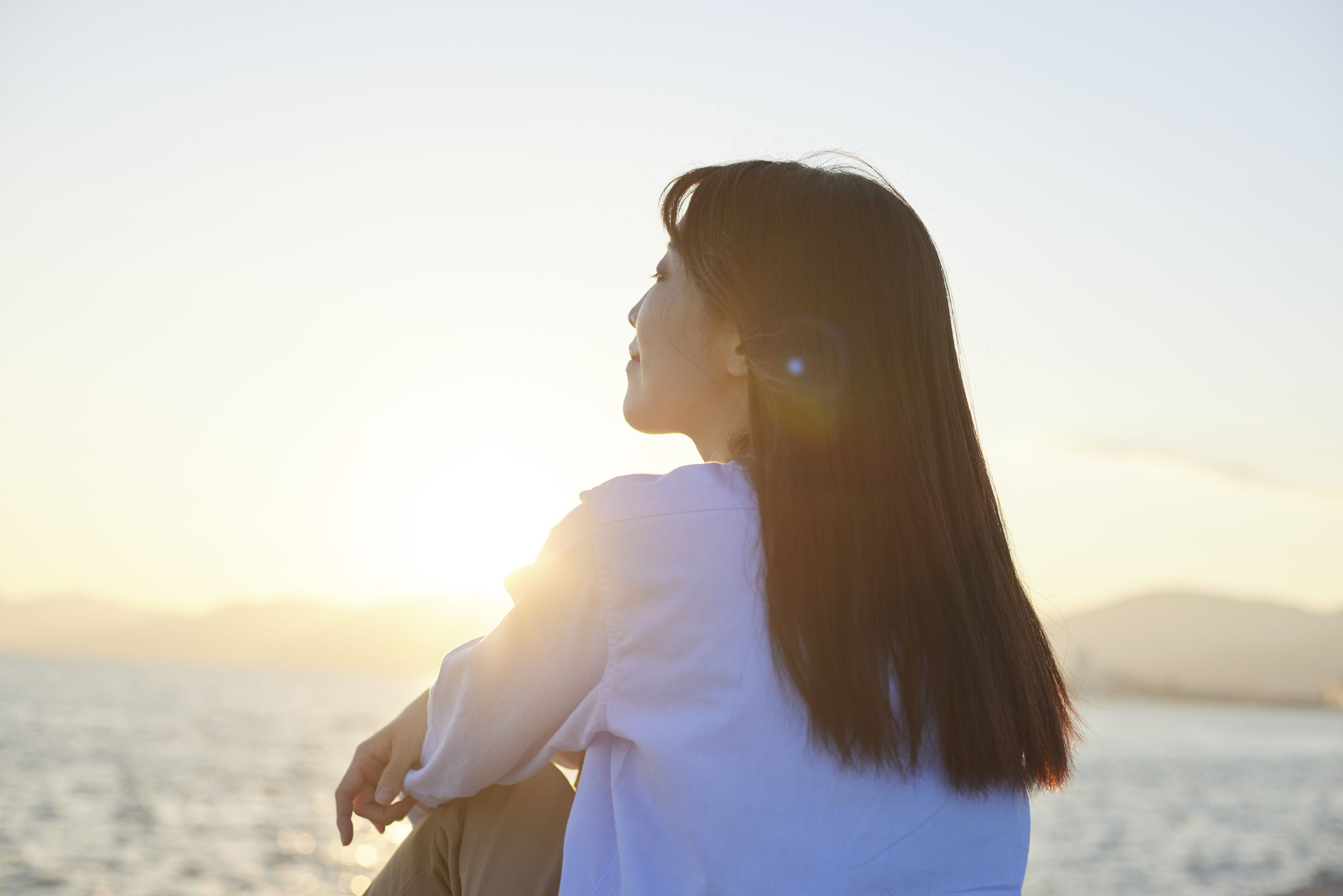 夕陽を見つめる女性